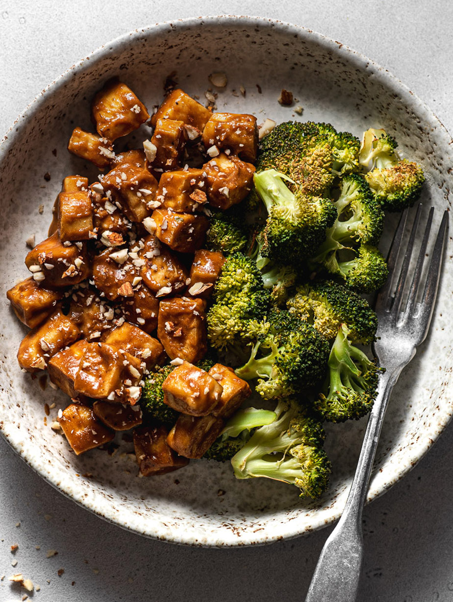 a bowl with baked tofu and roasted broccoli and an oil-free based tahini sauce.