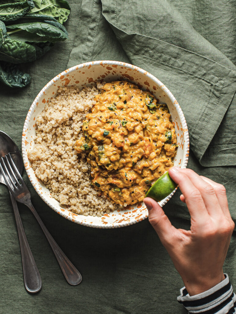 this is a bowl or cooked quinoa and creamy vegan dahl made with butternut squash and kale