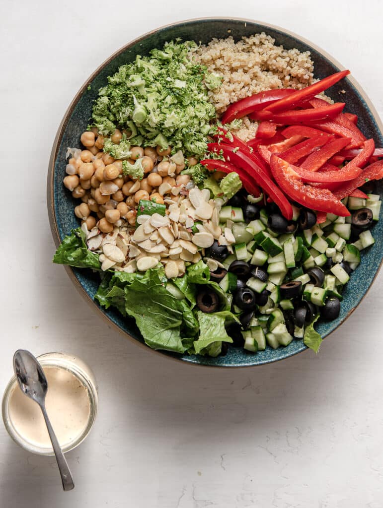 vegan chopped salad in a large bowl with a side of cashew dressing